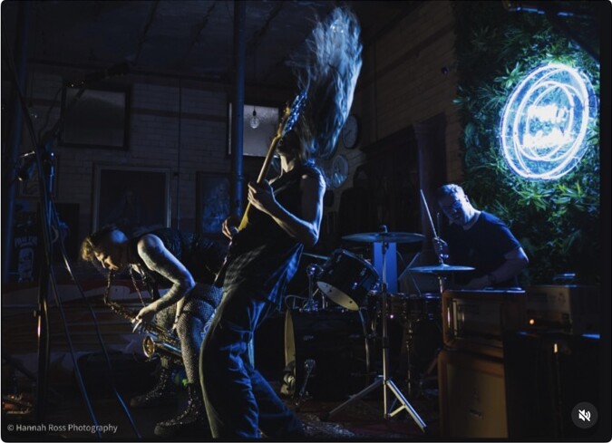 A band performing under blue lights at Peggy McCools
