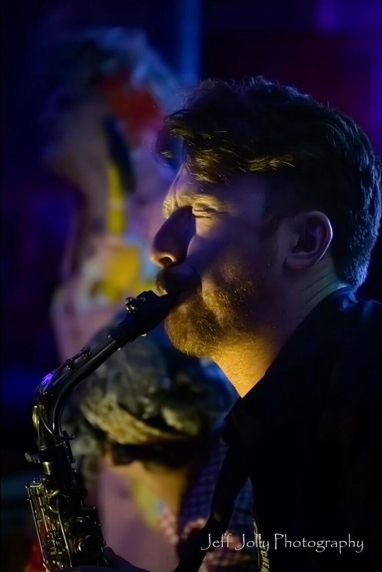 A saxophonist performing in blue and gold light