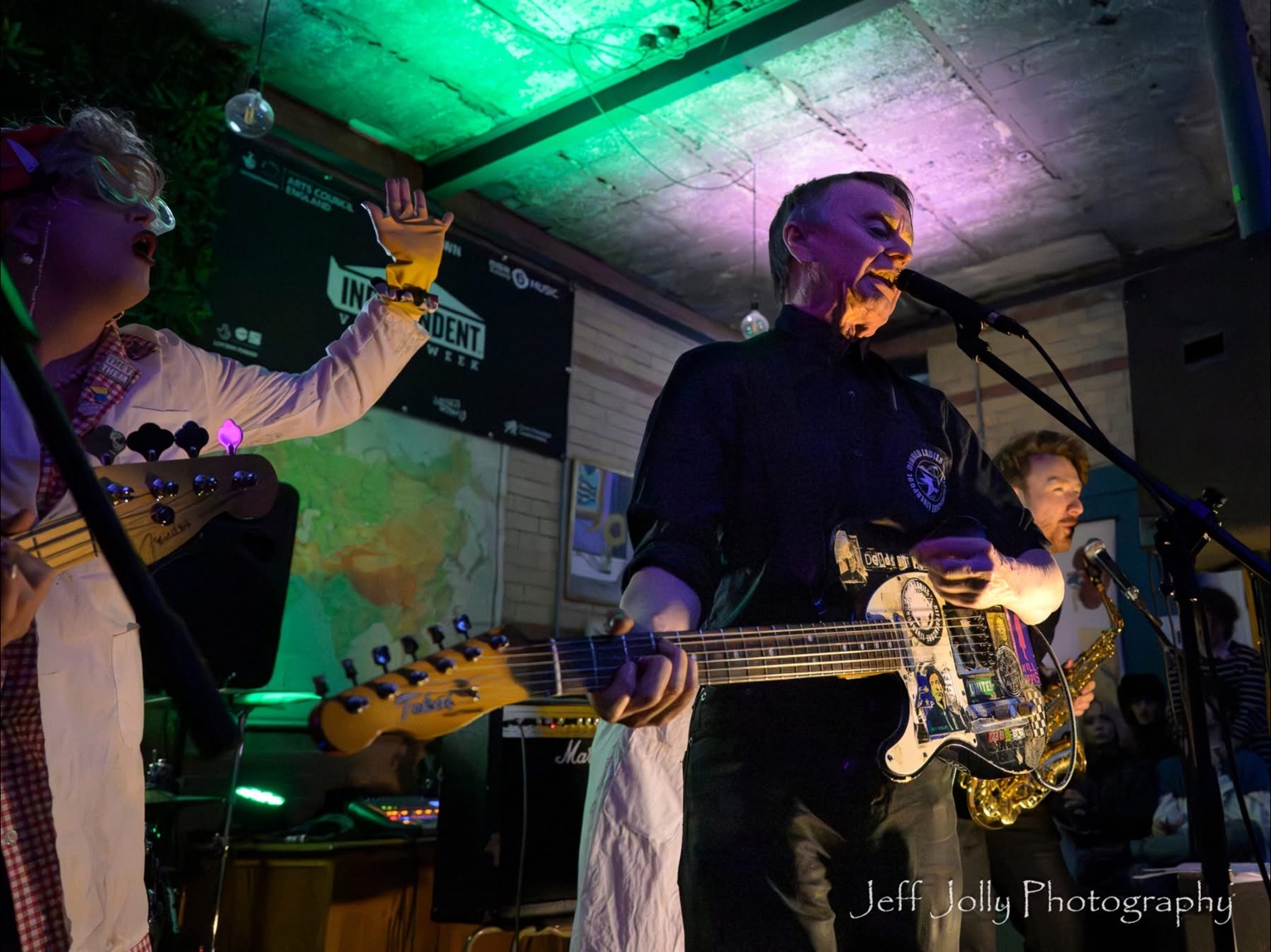 Costumed performers and a guitarist sharing the stage