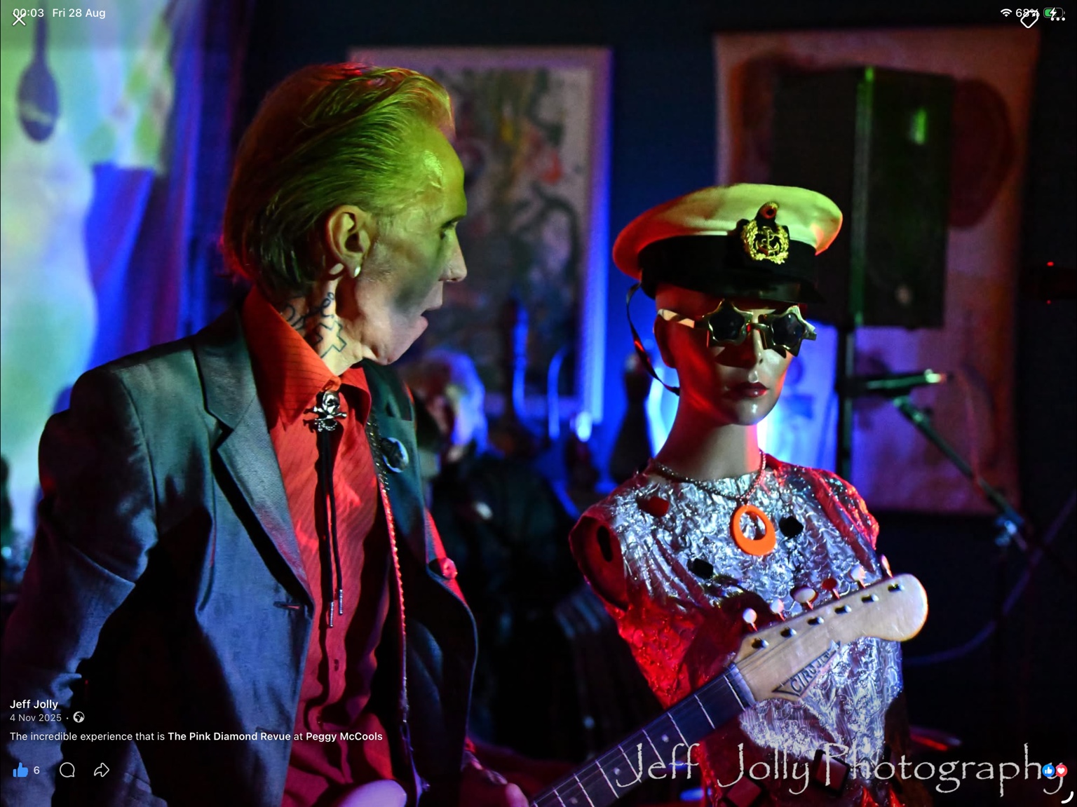 A performer beside a silver mannequin under red and blue lights