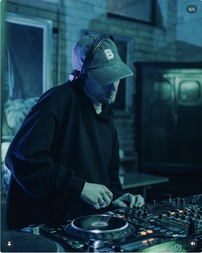A DJ performing under blue light at Peggy McCools