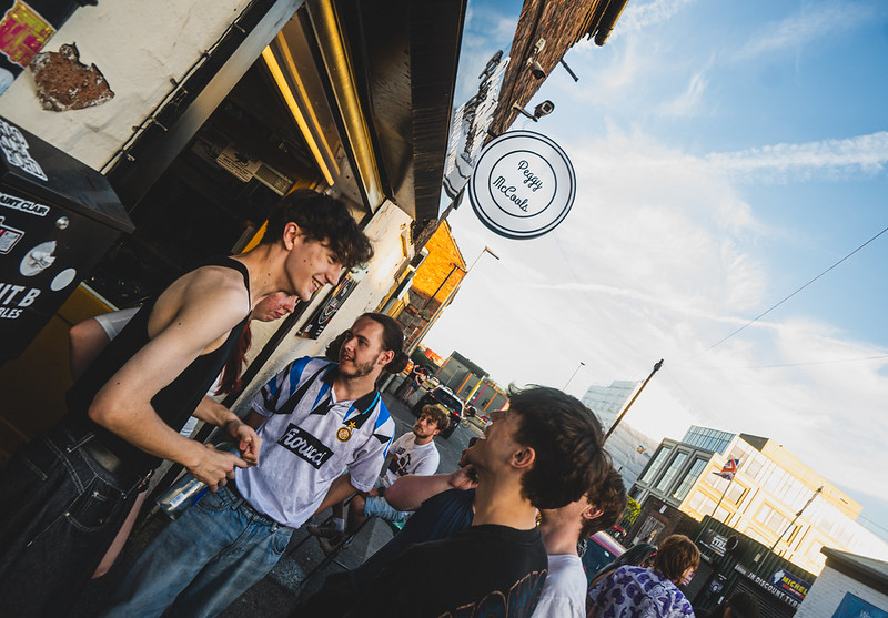 People chatting outside Peggy McCools on Erwood Street
