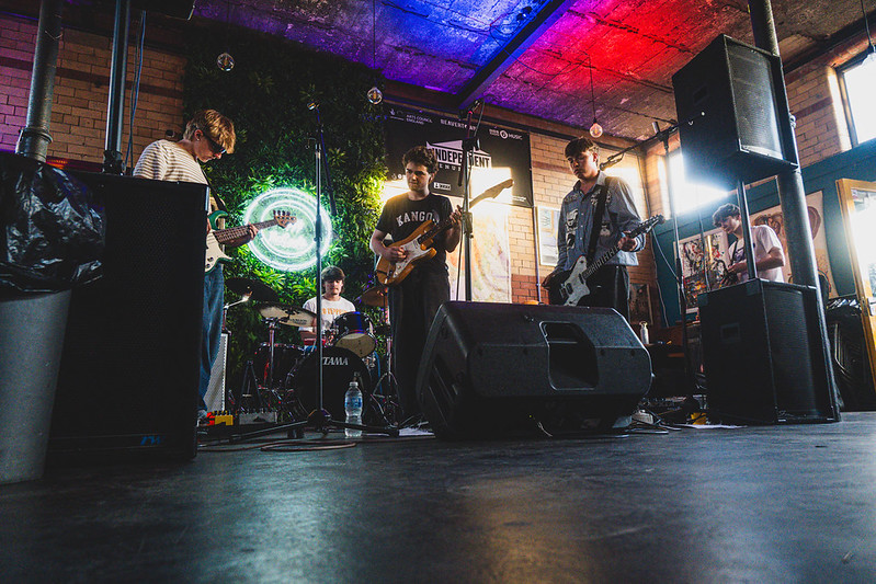 A crowd watching a live band under red and blue lights